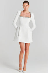 White mini dress with long sleeves and embellished square neckline