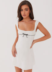 White mini dress with black bow detail