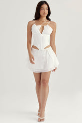 Vit korsett med öppen front och remmar samt flytande minikjol