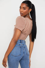 Korsett i brunt nät med puffärmar och veck