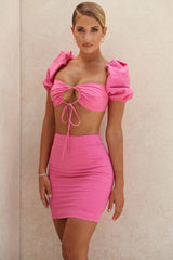 Korsettöverdel i rosa linne med puffärmar och minikjol