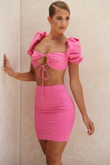 Korsettöverdel i rosa linne med puffärmar och minikjol