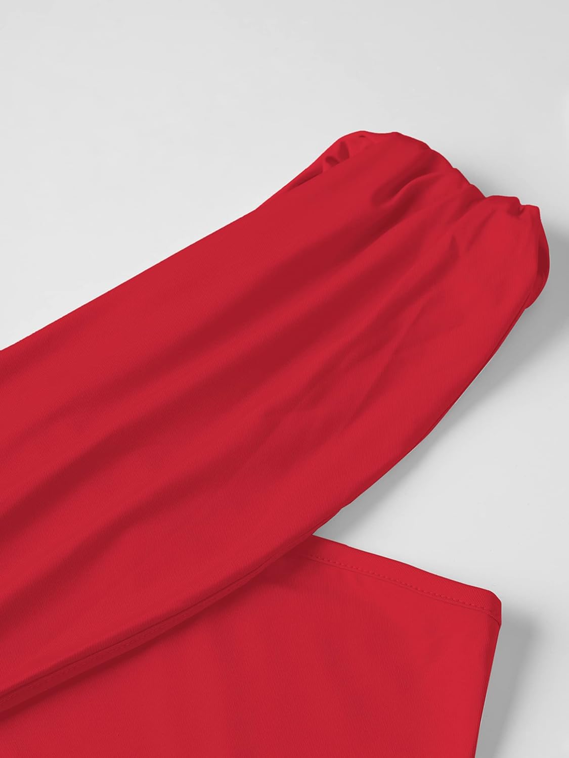 Red asymmetrical top with draped details and long sleeves