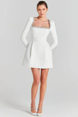 White mini dress with long sleeves and embellished square neckline