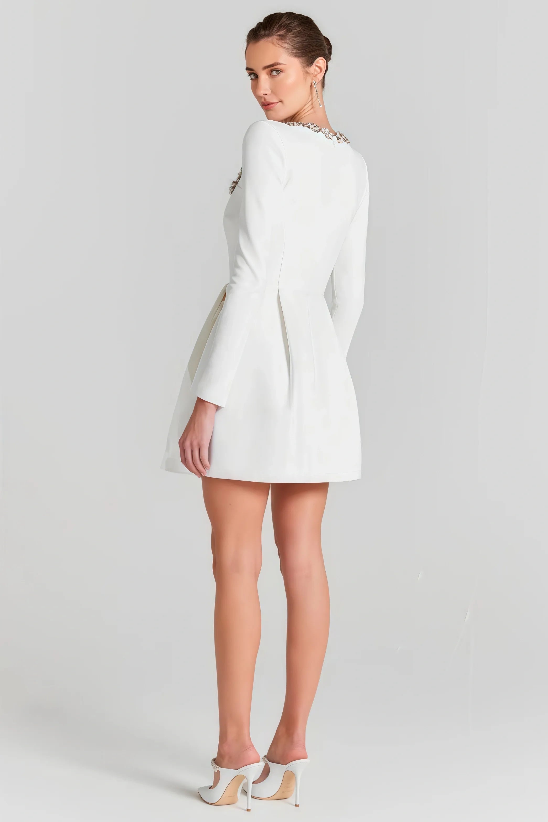 White mini dress with long sleeves and embellished square neckline
