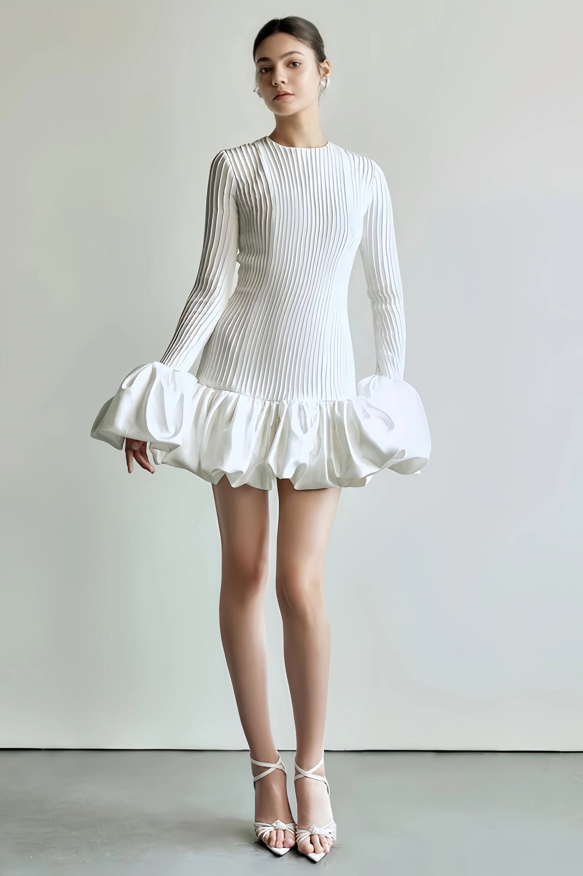 White mini dress with voluminous sleeves and pleated structure