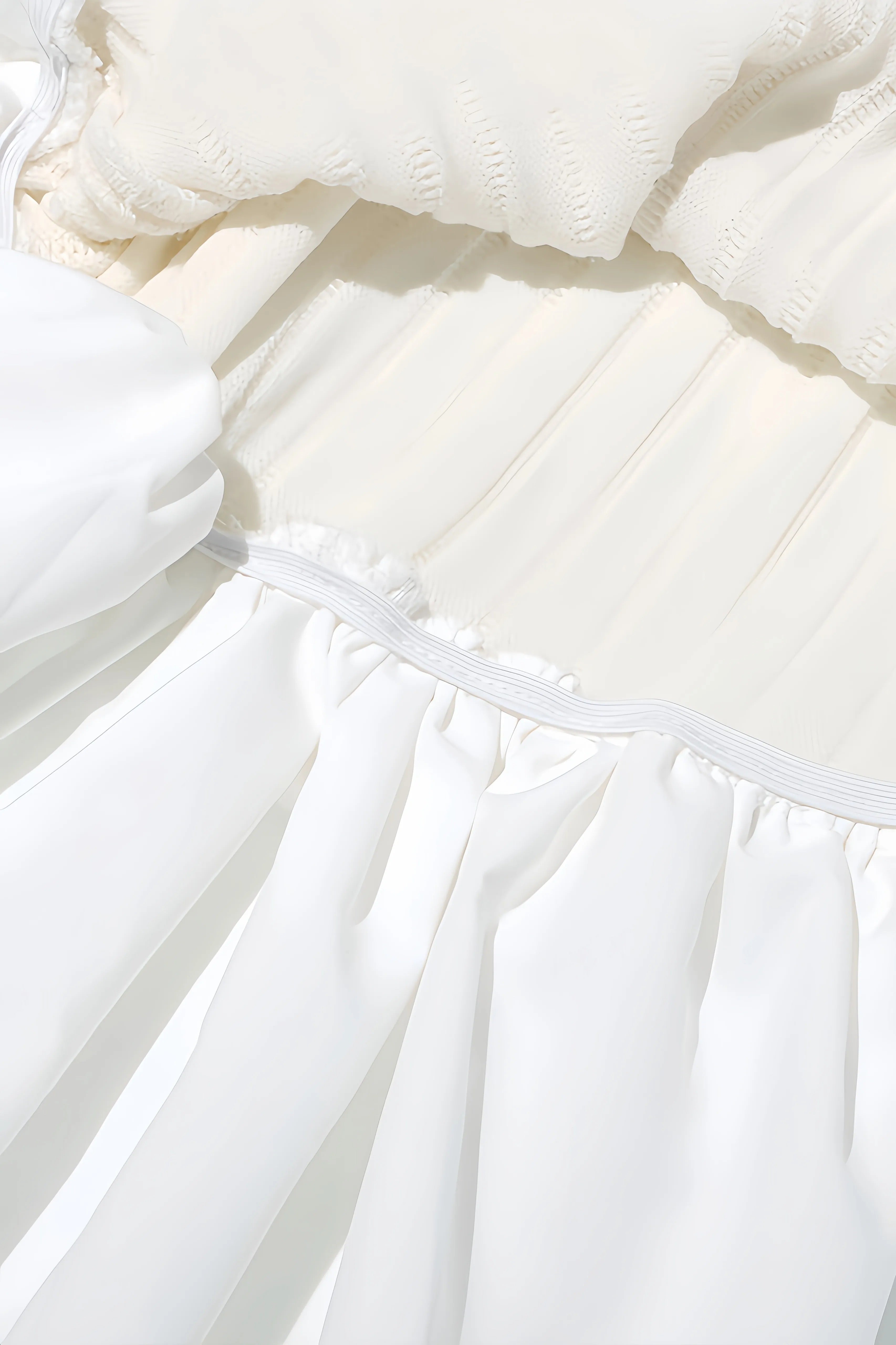 White mini dress with voluminous sleeves and pleated structure