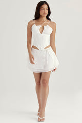 Vit korsett med öppen front och remmar samt flytande minikjol