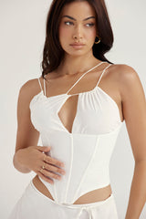 Vit korsett med öppen front och remmar samt flytande minikjol
