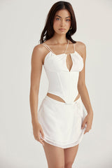 Vit korsett med öppen front och remmar samt flytande minikjol