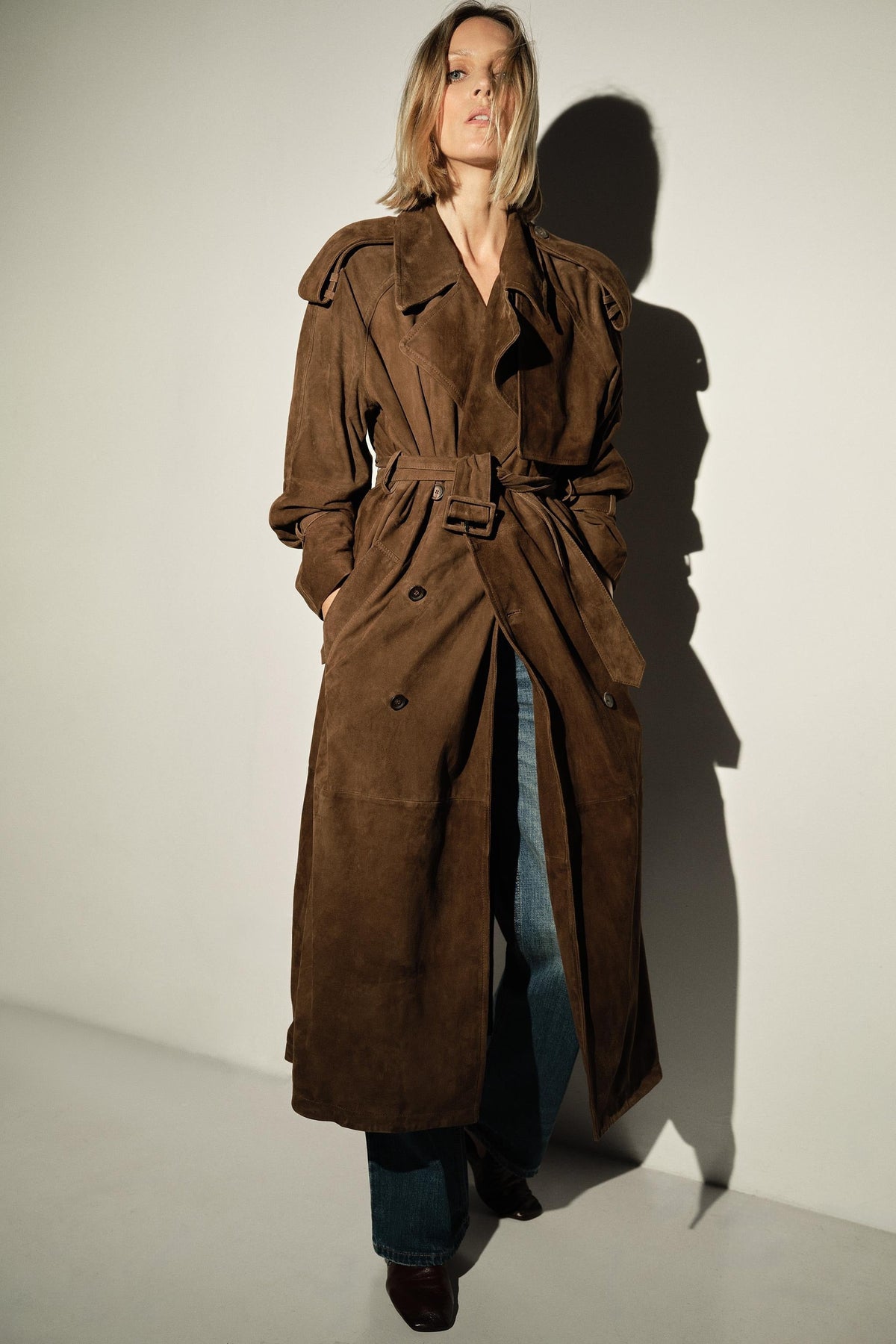 Brown trench coat with belt and shoulder details