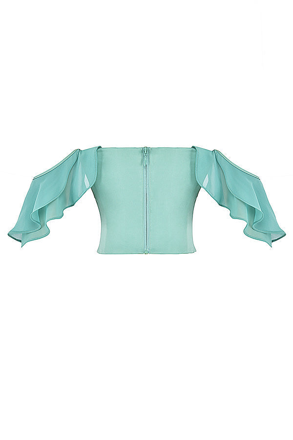 Jadekorsett med volanger på  ärmarna och maxikjol med volanger